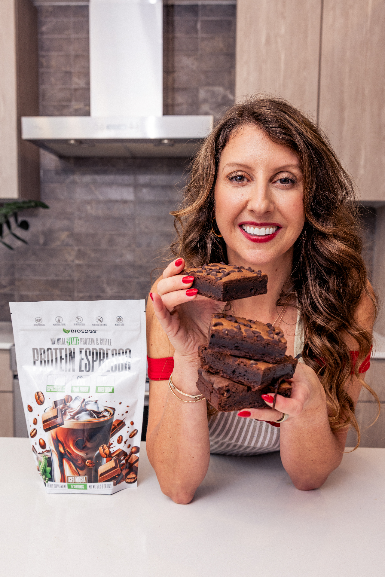 Simone Lovell holding fudgy protein brownies in her kitchen